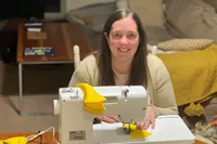 Photo of Caitlyn Bishop sewing 