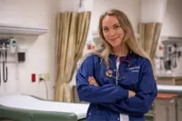A nursing student posing for pictures in the Simulation Lab 