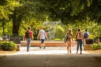 Students walking around the campus fountain 