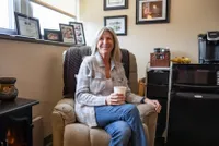 Barb Hanbury in her office holding a cup of coffee 