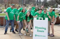 Spartan Ambassadors in front of a Housing Tours sign 