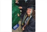 Isabel Cox signing the rock after Commencement. 