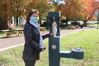 Jennifer with mask on at outdoor water bottle refill station 