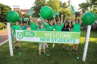 A group of Orientation leaders posing for a photo in all green