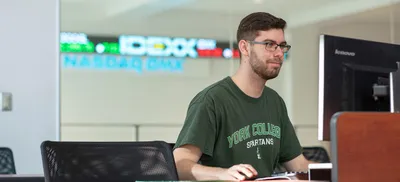 York College Finance Student using a computer in the NASDAQ Trading Lab