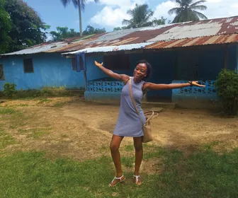 Cathy Cooper '19 stands in front of her childhood home in Liberia. 