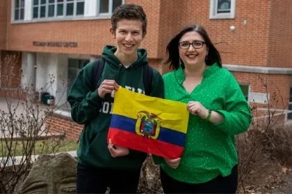 An Undeclared international student holding the Ecuador flag with his host who also works at York College 