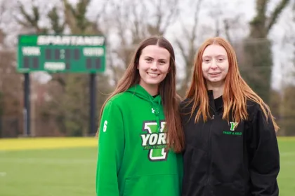 Isabella Ewing and Katie Martino on lacrosse field 