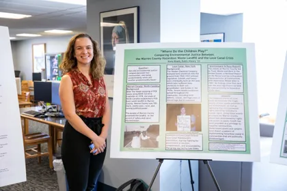 Keely Bluett in front of her undergraduate research poster 