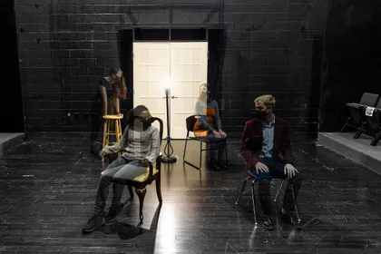Semi-transparent images of students are photoshopped in a photo of the blackbox theater 