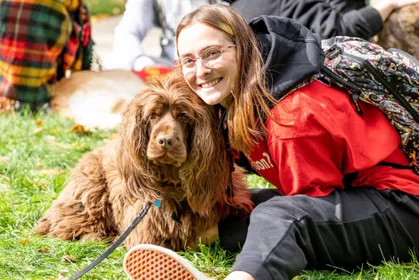 Therapy dogs on campus posing with a student. 