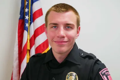 Officer Chad Gleissl's headshot, taken in front of an American flag. 