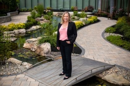 Tracy Miller, YCP Alum and now the Chief Nursing Officer at UPMC Memorial posing for a photo in a beautiful garden