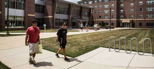 Students walking through the modern West Campus housing area at York College