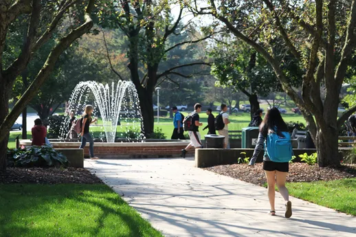 Students walking to class on campus around fountain