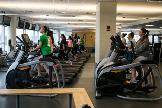Students exercise on fitness equipment in the fitness center.