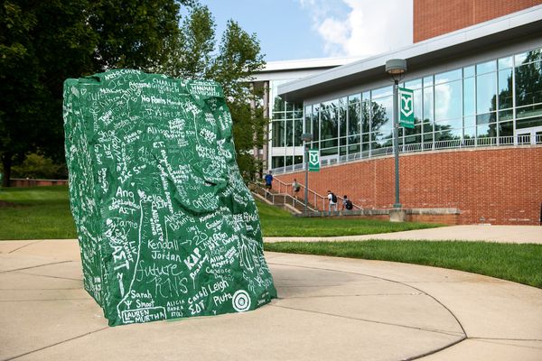The iconic rock sits in the middle of campus, painted green and covered in names of graduates, written in white