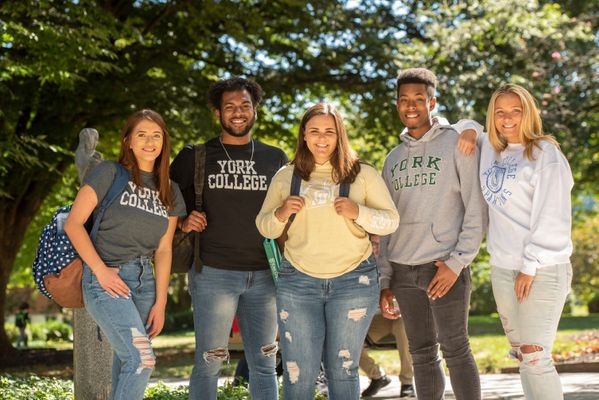 Five students posing for a photo with York College Merch on